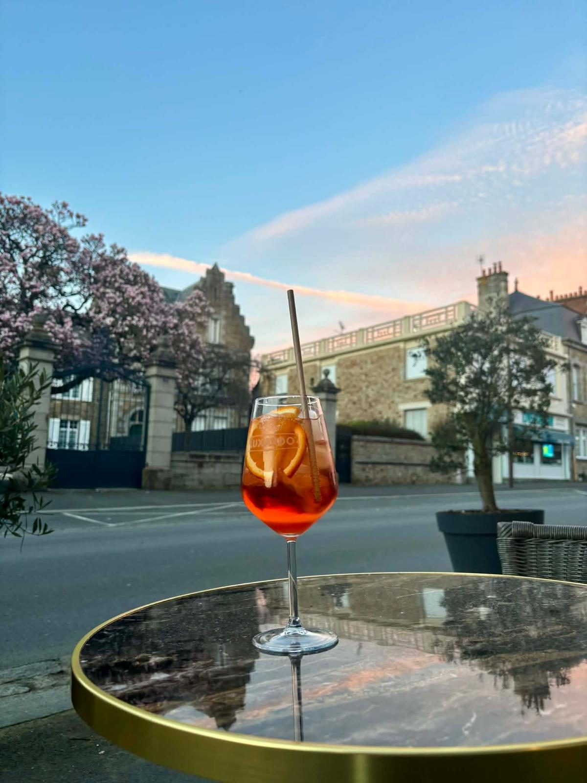 La terrasse de L'Atelier Montois au coucher du soleil, un spritz sur la table